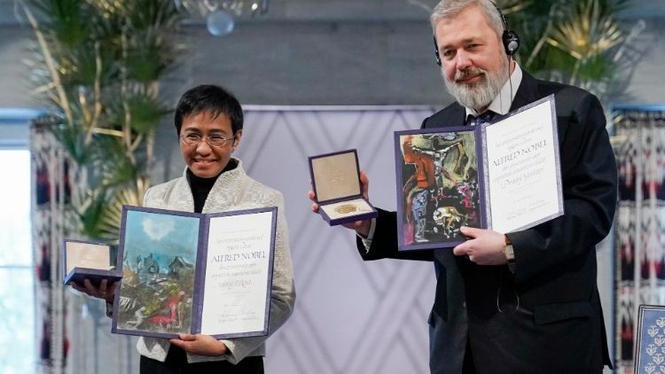 Maria Ressa (L) and Dmitry Muratov with the Nobel Peace Prize in Oslo, Norway, on 10 Dec. 2021.   
