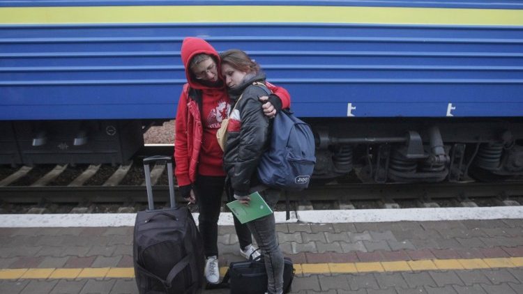 Ukrainian refugees prepare to board a train to Poland from Odessa