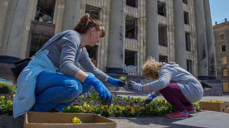 Wstępuje w nas nadzieja. Ukrainki sadzą kwiaty przed zniszczonym budynkiem magistratu w Charkowie.