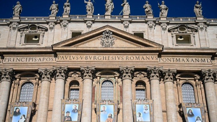 Bilder av de nye helgenene hengt opp på fasaden av Peterskirken