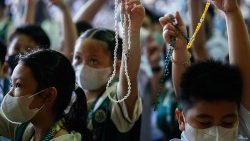 Des enfants prient le chapelet aux Philippines.