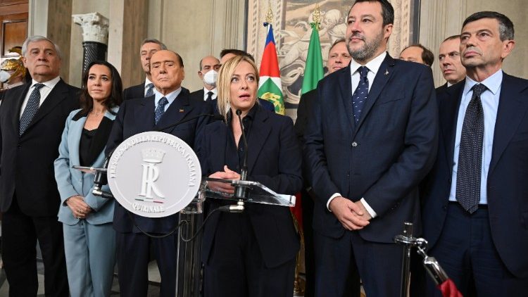 Giorgia Meloni (C) speaks at a press conference, flanked by Matteo Salvini (R) and Silvio Berlusconi (L)