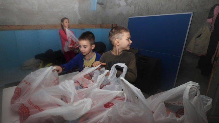 Crianças ucranianas recebem ajuda humanitária em Kherson, em 19 de dezembro. EPA/Sergey Kozlov
