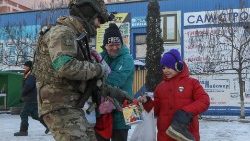 Ukraiński żołnierz dający na ulicy dziecku słodycze, Bachmut, 9 stycznia 2023
