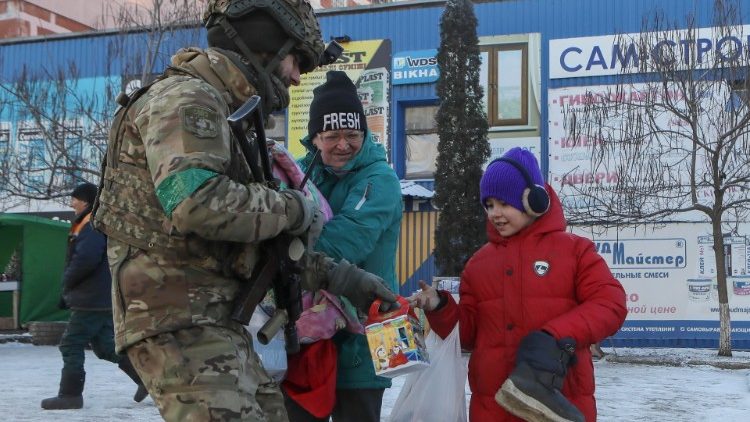 Ukraiński żołnierz dający na ulicy dziecku słodycze, Bachmut, 9 stycznia 2023
