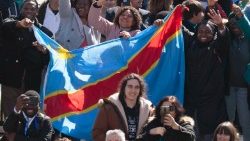 Congolese nationals holding the flag of the DRC during the Angelus of 12. 02. 2023.