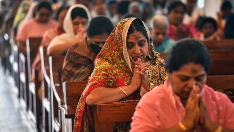 Indian Catholic faithful praying in a church. 