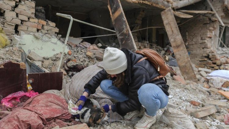 Uma menina resgata um cachorro dos escombros depois que dois foguetes atingiram prédios privados no distrito de Zolochiv, perto da cidade de Lviv, no oeste da Ucrânia, em 9 de março de 2023. EPA/MYKOLA TYS