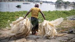 Ein Arbeiter ordnet Plastiktüten zum Trocknen in der Nähe des Buriganga-Flusses in Dhaka, Bangladesch, 22. Mai 2023.