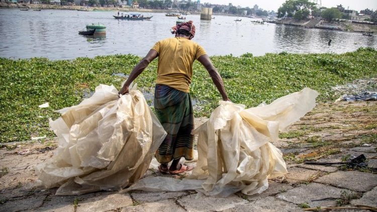 Ein Arbeiter ordnet Plastiktüten zum Trocknen in der Nähe des Buriganga-Flusses in Dhaka, Bangladesch, 22. Mai 2023.