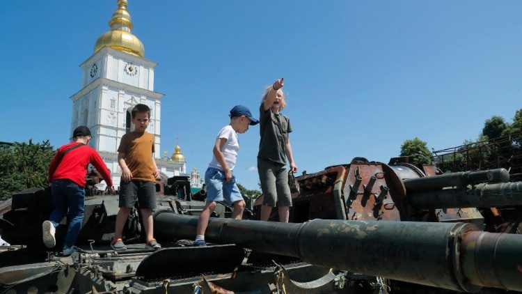 Crianças brincam no maquinário militar russo danificado exibido durante um evento para apoiar crianças, perto da Catedral de St. Mykhailivsky em Kiev, Ucrânia, 04 de junho de 2023 em meio à invasão russa. EPA/SERGEY DOLZHENKO