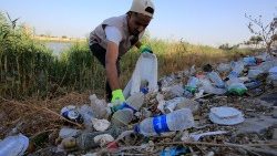 Un voluntario iraquí recoge plástico cerca del río Tigris