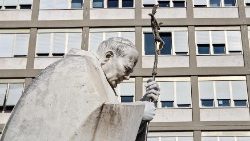 Estátua de João Paulo II tendo ao fundo fachada do Germelli
