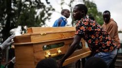 Angehörige tragen einen Sarg mit der Leiche eines Opfers eines Schulanschlags aus einer Leichenhalle in Mpondwe, Uganda