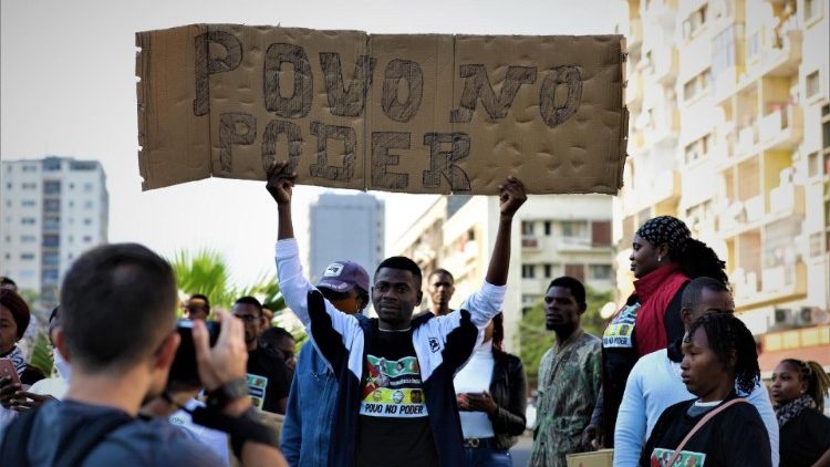 An activist holds a poster that reads 'People in Power'