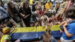Artyści i dzieci podpisują ukraińską flagę w Buczy, 30 czerwca 2023