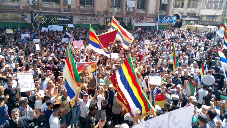 Demonstranten schwingen Fahnen mit den Farben der Drusen bei einer Demonstration in Suweida am 8. September