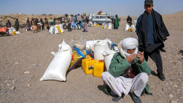 Persone colpite dal terremoto dello scorso 7 ottobre attendono soccorsi nella zona di Herat (Ansa)