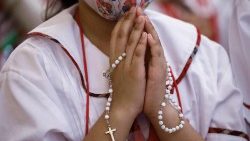 Una bambina prega per la pace durante l'iniziativa "one million children praying the rosary" di ACS