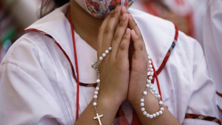 Una bambina prega per la pace durante l'iniziativa "one million children praying the rosary" di ACS