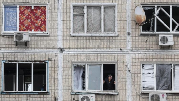 Pessoas consertam janelas quebradas no local de um edifício residencial danificado após um ataque com mísseis em Kiev, em 13 de dezembro de 2023. (EPA/OLEG PETRASYUK)