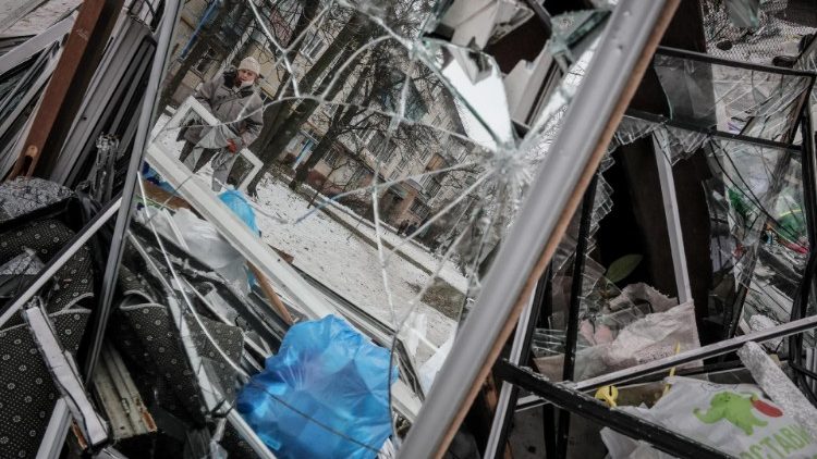 Janelas quebradas são levadas para um ponto de coleta de lixo próximo ao local de um edifício residencial danificado após um ataque com mísseis em Kiev, 13 de dezembro de 2023. (EPA/OLEG PETRASYUK)