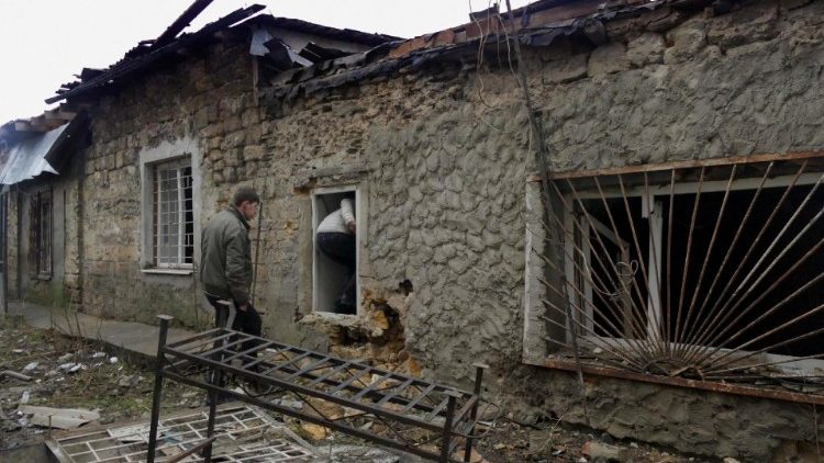 Um homem inspeciona uma casa danificada após um ataque noturno de drone em Odesa, sul da Ucrânia, 14 de dezembro de 2023. EPA/IGOR TKACHENKO