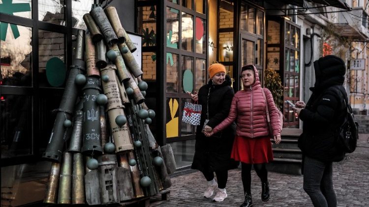 Pessoas passam por uma árvore de Natal feita de munição usada e instalada perto de um café em uma rua no centro de Kiev, Ucrânia, 19 de dezembro de 2023. EPA/Oleg Petrasyuk
