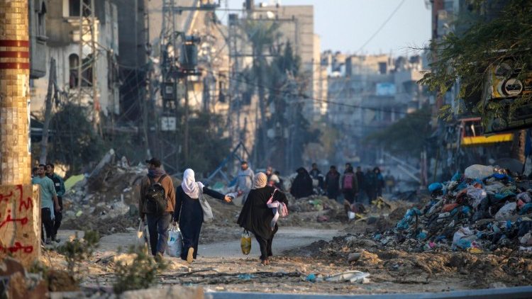 Personas entre los escombros de Gaza