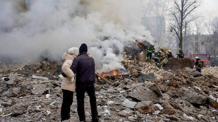 Moradores olham para os escombros depois que um foguete atingiu um prédio residencial em Kharkiv, nordeste da Ucrânia, em 23 de janeiro de 2024, em meio à invasão russa. EPA/SERGEY KOZLOV