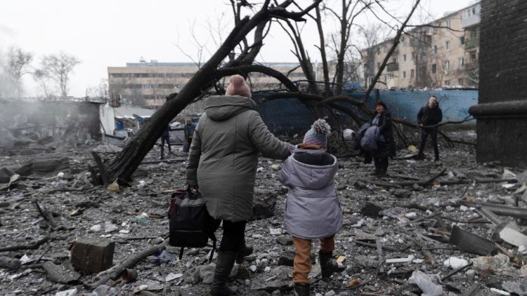 Moradores caminham sobre os escombros no local de um ataque com foguete a um prédio residencial em Kharkiv, nordeste da Ucrânia, em 23 de janeiro de 2024, em meio à invasão russa. EPA/YAKIV LIASHENKO
