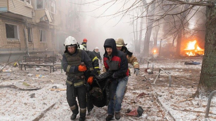 Equipes de resgate ucranianas carregam uma mulher ferida no local de um ataque com foguete a um prédio residencial em Kharkiv, nordeste da Ucrânia, em 23 de janeiro de 2024, em meio à invasão russa.