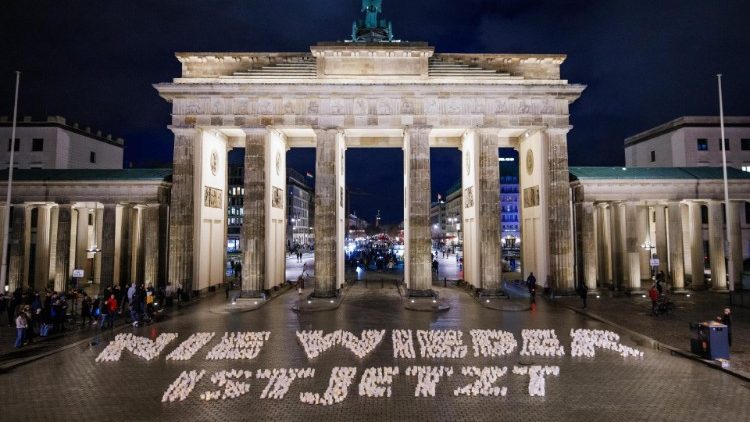 Kerzen bilden eine Parole im Protest gegen den Faschismus am Brandenburgertor in Berlin