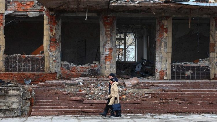 Um casal caminha perto dos escombros de edifícios destruídos em Kupiansk, região de Kharkiv, Ucrânia, 8 de fevereiro de 2024, em meio à invasão russa. De acordo com autoridades ucranianas, as forças russas têm intensificado a sua ofensiva na área da frente de Kupiansk há mais de seis meses, enquanto tentam recuperar o controlo da cidade desde 2022, quando as forças ucranianas recapturaram o controlo da área na contra-ofensiva de Kharkiv. EPA/ANTÔNIO COTRIM