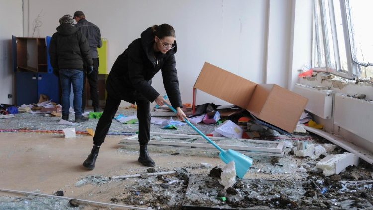 Moradores removem destroços de um foguete atingido perto de uma escola após bombardeio matinal em Lviv, oeste da Ucrânia, em 15 de fevereiro de 2024, em meio à invasão russa. Pelo menos 18 prédios residenciais, duas escolas e um jardim de infância foram danificados no bombardeio russo na cidade de Lviv, no oeste, disse o prefeito de Lviv, Andriy Sadovyi, em 15 de fevereiro, acrescentando que três pessoas ficaram feridas no ataque. EPA/MYKOLA TYS