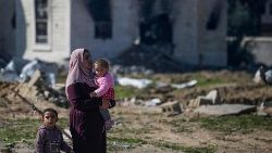 गाजा पट्टी में फिलिस्तीनी महिला अपने दो बच्चों के साथ 