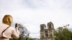 Una mujer toma una fotografía de la catedral de Notre-Dame en París, Francia, el 15 de abril de 2024. Cinco años después del derrumbe de la aguja de la catedral de Notre-Dame en un devastador incendio el 15 de abril de 2019, su reapertura está prevista para diciembre de 2024, según Philippe Jost, presidente del organismo público que supervisa su reconstrucción. EPA/MOHAMMED BADRA