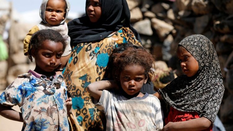 Children stand at a makeshift camp for internally displaced people near Sanaa, Yemen