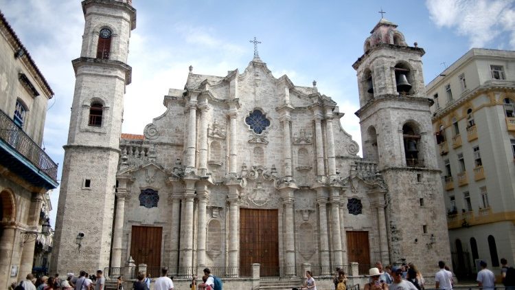 Tourists and locals walk near temporary fencing set up outside the Cathedral of Havana after the death of 82 years old Cardinal Jaime Ortega was announced on Friday, in Havana