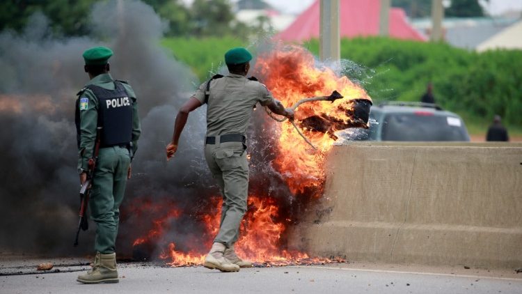 Polizisten löschen ein Feuer an einer Straße in Nigeria im Jahr 2019