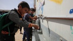 Des enfants syriens se lavent les mains au camps de réfugiés de Mafraq, en Jordanie