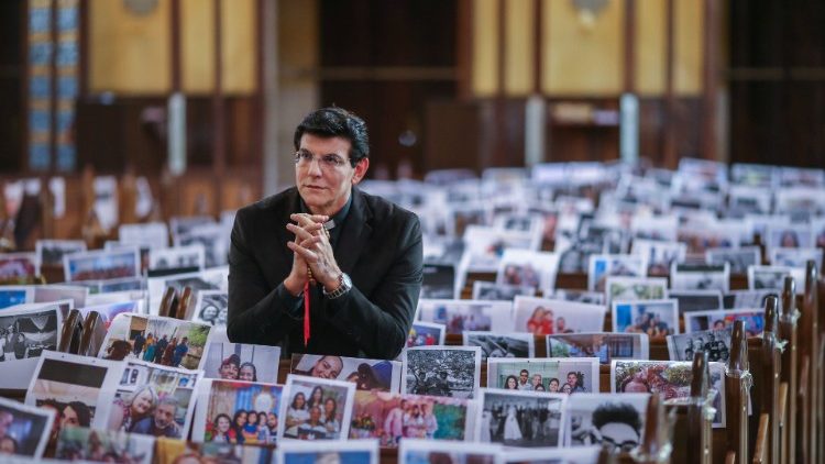 Kyrkoherde i Brasilien ber i sin tomma kyrka med bilder på församlingsmedlemmarna 