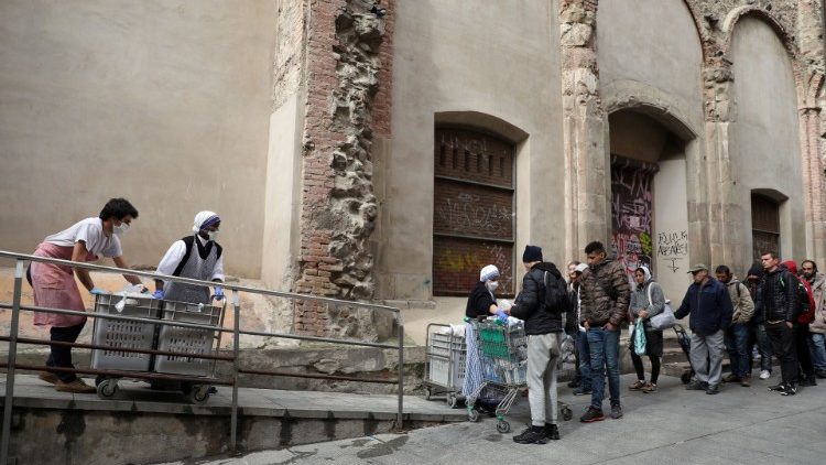 Irmãs de Madre Teresa com máscaras protetoras distribuem alimento aos sem-teto no distrito de Raval, em Barcelona