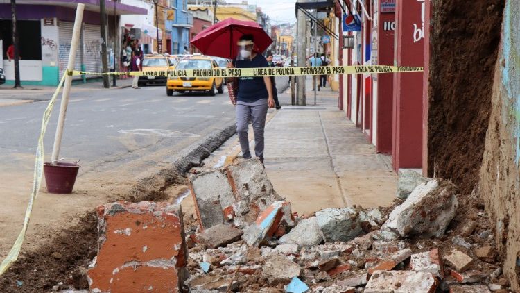 A woman walks by debris from a building damaged by the earthquake in Oaxaca, Mexico
