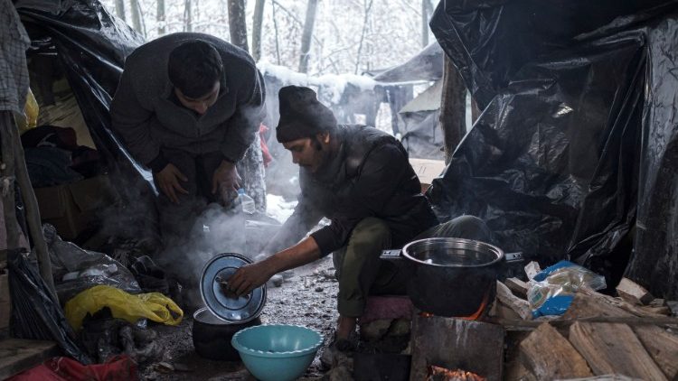 Migrants from Bangladesh prepare food at a makeshift camp in Bosnia