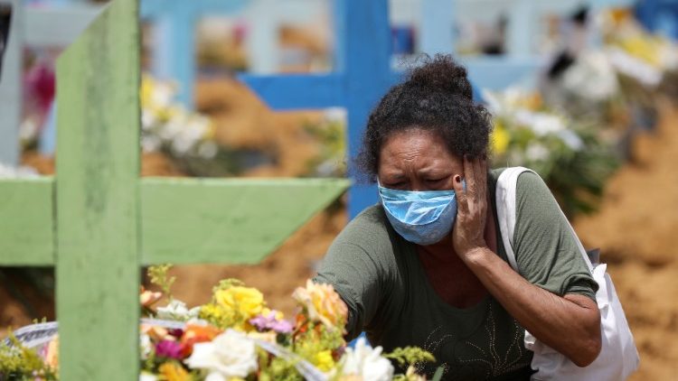 A woman mourns a family member who died from covid-19 in the Parque Taruma cemetery in Manaus
