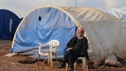 An internally displaced Syrian woman in front of her tent
