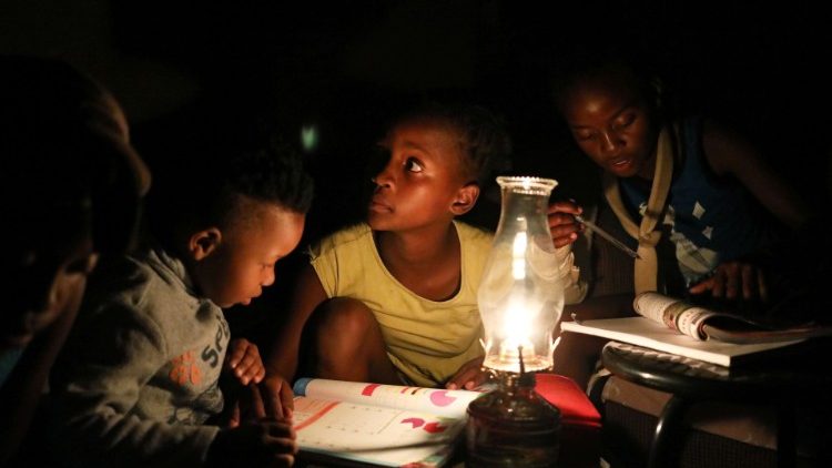 Des enfants de Soweto étudiant à la lumière de la bougie. 
