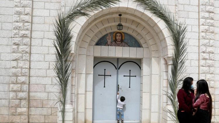 A Palestinian child tries to open a door at a church in Gaza
