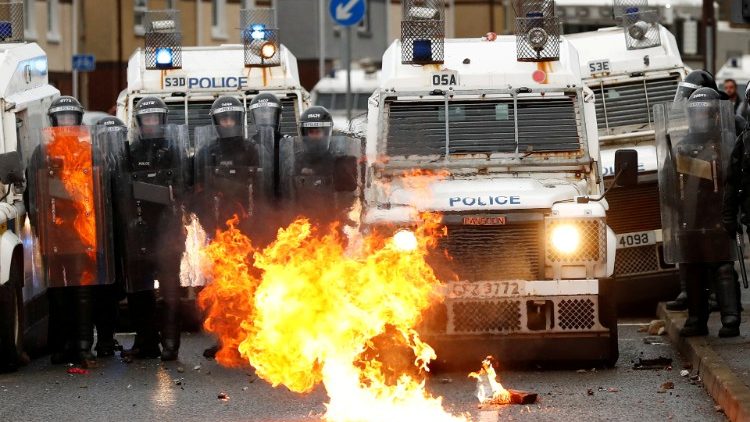 A fire burns in front of police in Belfast, Northern Ireland, on 8 April